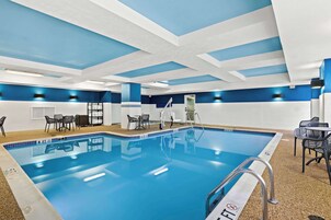 Una piscina techada, sillones reclinables de piscina