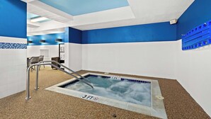 A hot tub with a 3 FT depth marker, surrounded by blue and white walls, and a metal ladder leading into the tub.