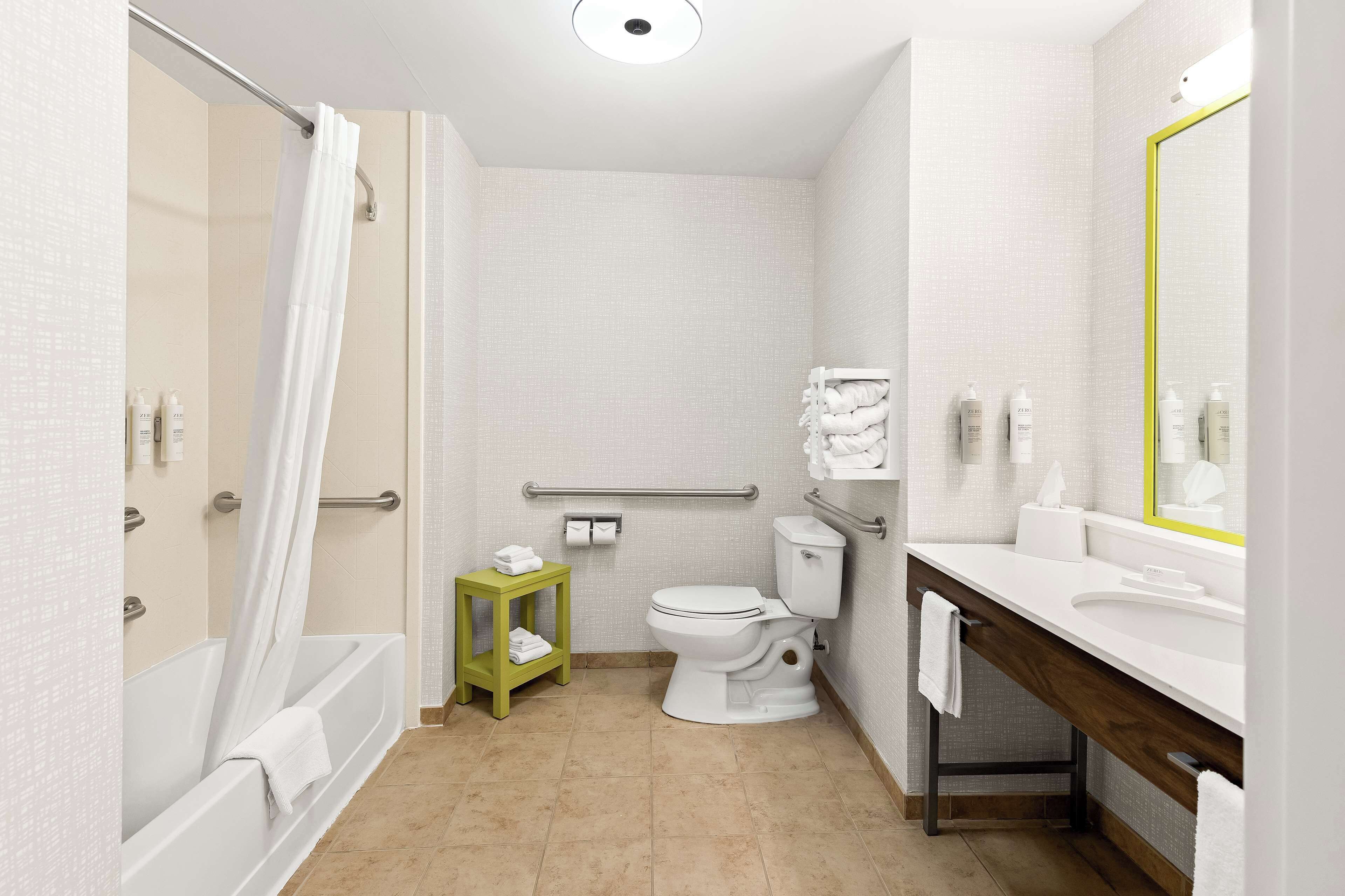 A modern bathroom with a bathtub, toilet, and vanity.