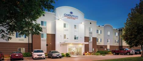 A hotel with a prominent sign, multiple parking spaces, and a well-maintained lawn.