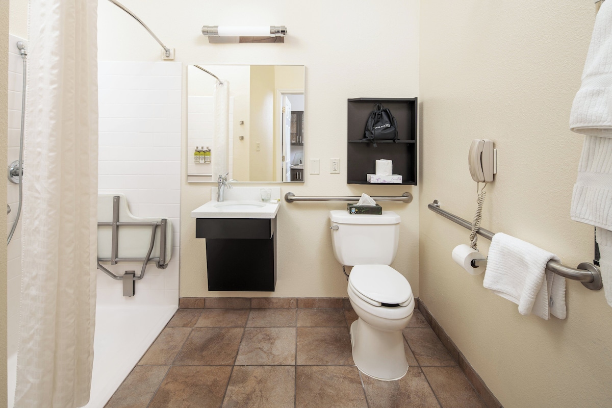 Un baño con inodoro, lavabo y zona de ducha.