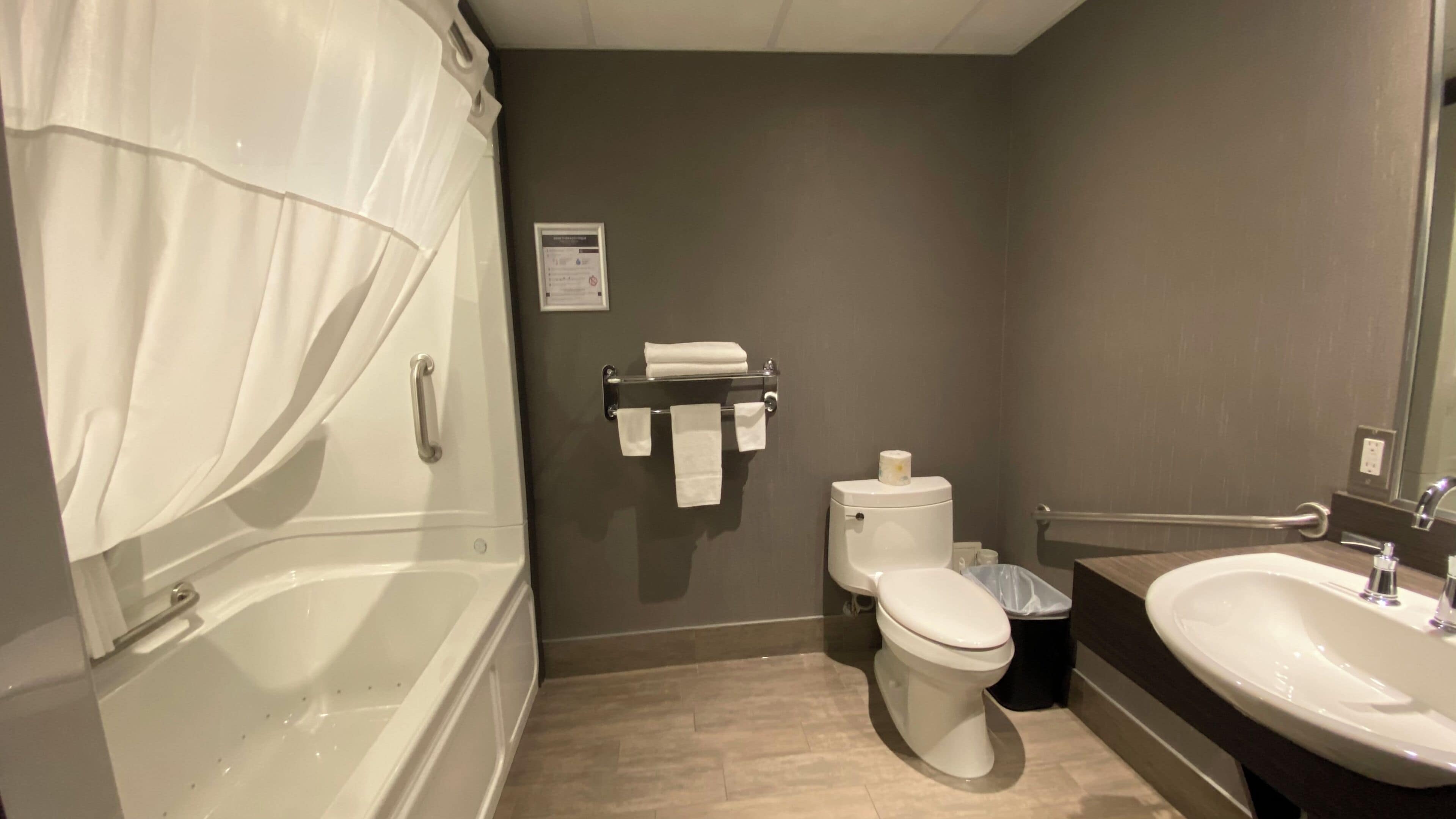 Et badeværelse med badekar, toilet og håndvask.