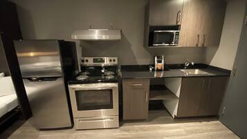 Una cocina compacta equipada con refrigerador, estufa, horno, microondas y lavaplatos.