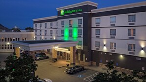 A Holiday Inn & Suites with a gas station, multiple floors, and a parking lot.