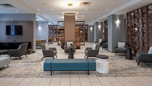 A modern lounge area with sofas, a coffee table, and a TV.