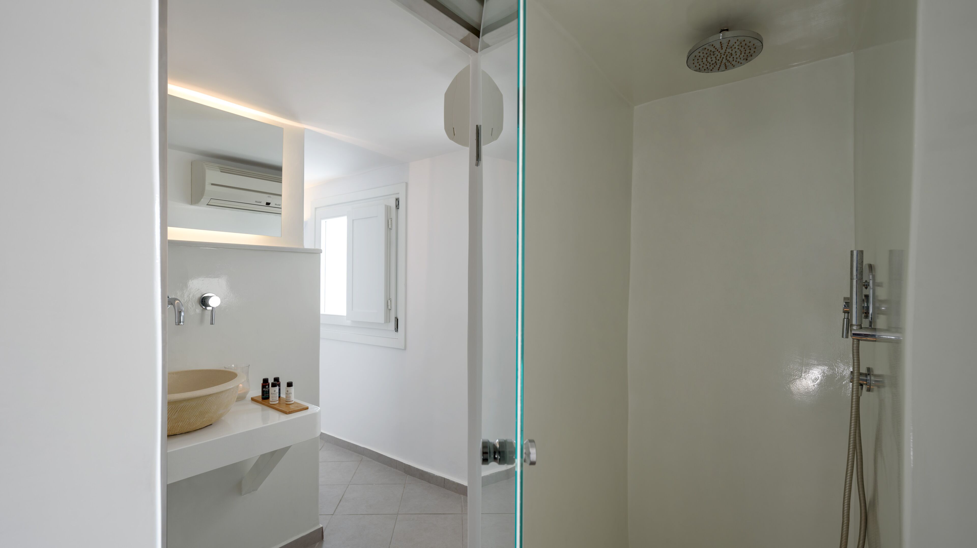 A modern bathroom with a shower, a sink with a bowl, and a mirror.