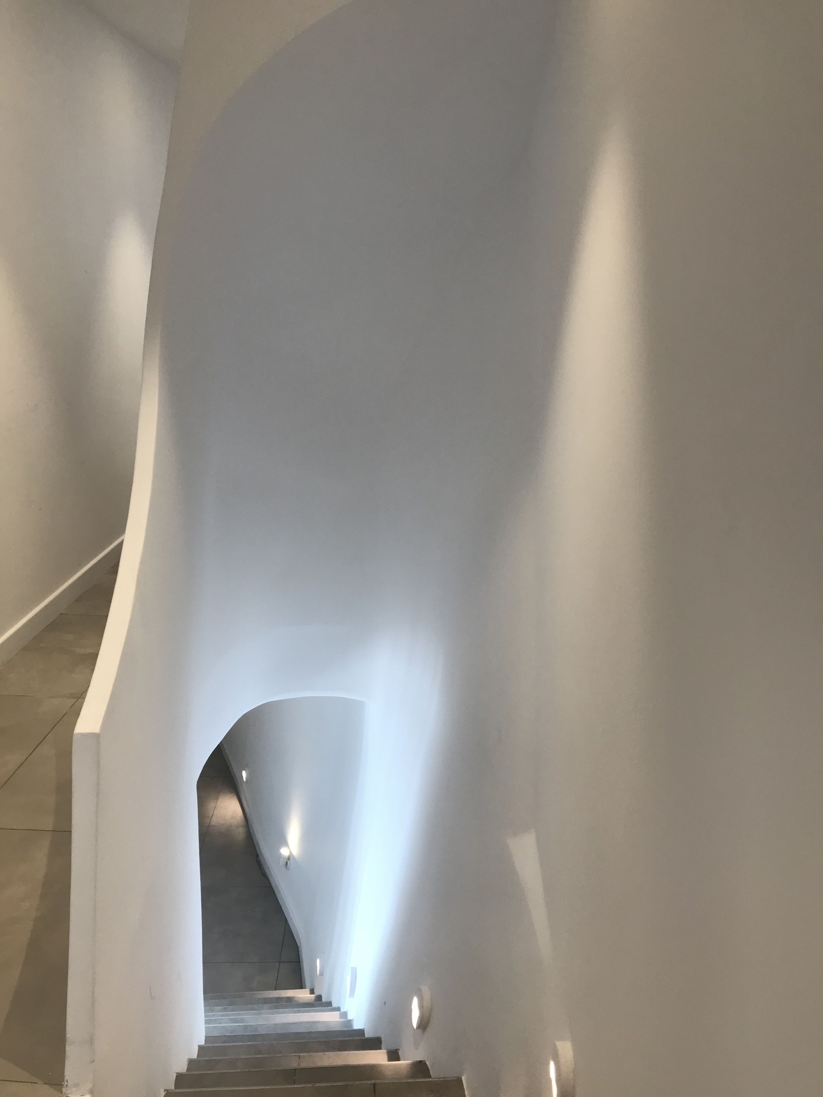 Una escalera curva de diseño moderno que conduce a un piso superior.