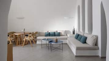 A modern living room with a sofa, coffee table, and dining area.
