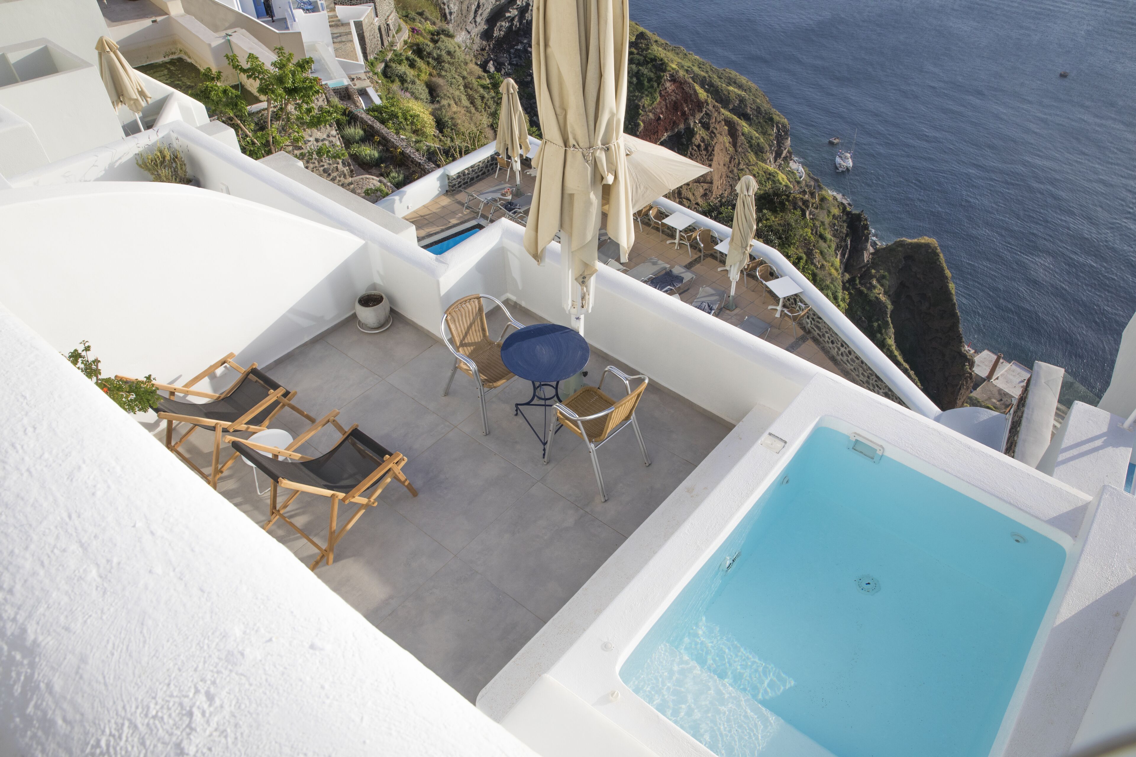 Une terrasse sur le toit avec une piscine, des espaces salons extérieurs et une vue sur la mer.