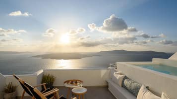 A terrace with a view of the sea, a pool, and seating areas.