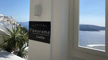 Señalización de 'Panorama Suites' con vista a un pueblo costero y al mar.