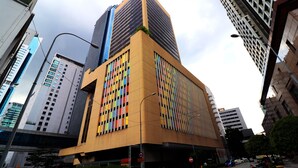 Un edificio moderno con una fachada singular que presenta una cuadrícula de paneles coloridos.