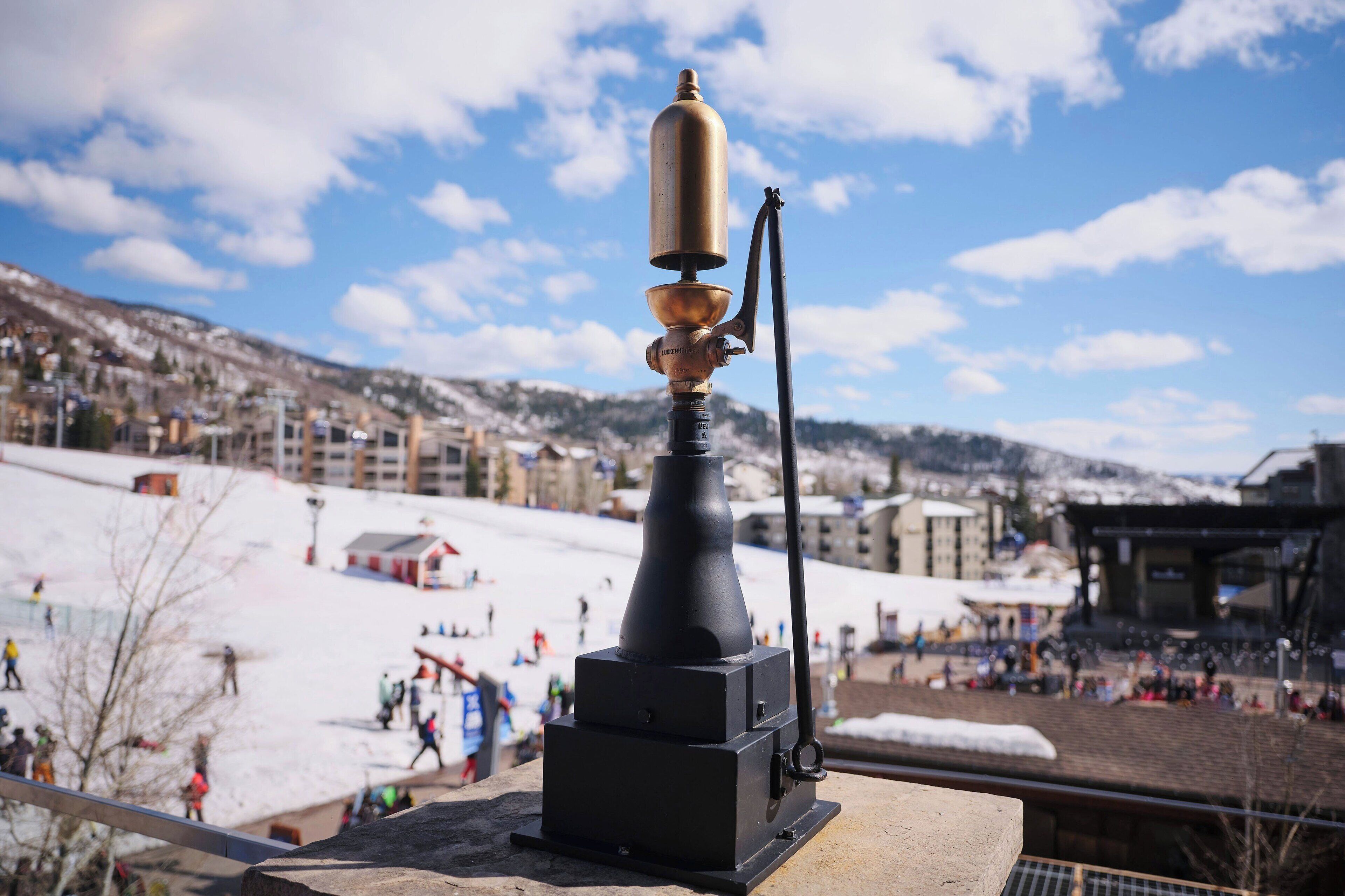 Pista de esquí cubierta de nieve con un telesilla negro y dorado en primer plano.