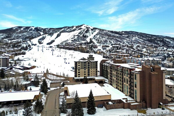 Une station de ski comprenant plusieurs bâtiments, un télésiège et des pistes enneigées.