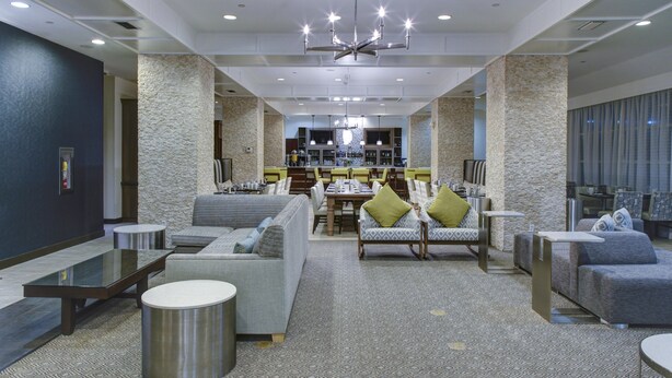A spacious lobby with a bar area, seating arrangements, and a patterned carpet. - DoubleTree by Hilton Hotel Biloxi (Biloxi)