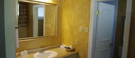 A bathroom with a sink, mirror, and towel rack.