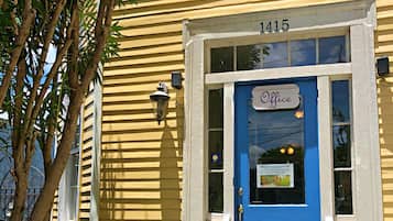 A yellow building with a blue door, number 1415, and a sign that says "Office".