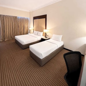 A hotel room with two beds, a large mirror, a desk with a lamp, and a chair. - Silka Maytower Kuala Lumpur (Kuala Lumpur)