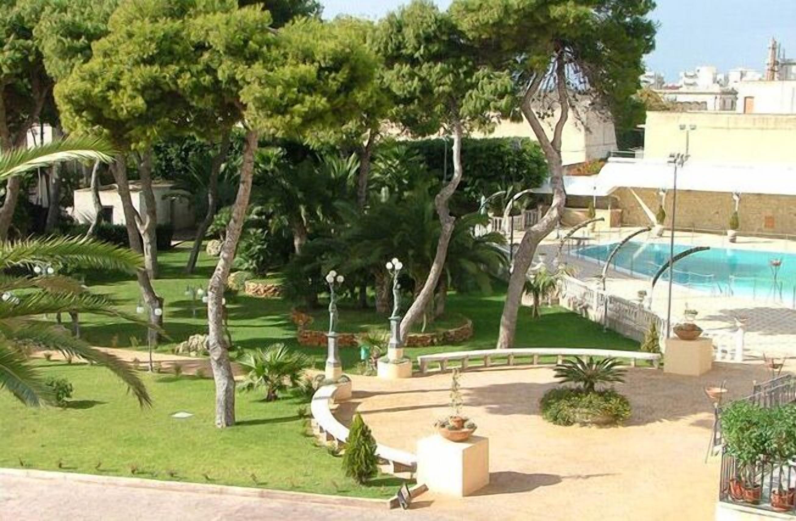 Un espace piscine offrant une vue dégagée sur l’eau, entouré d’arbres et d’une pelouse bien entretenue.