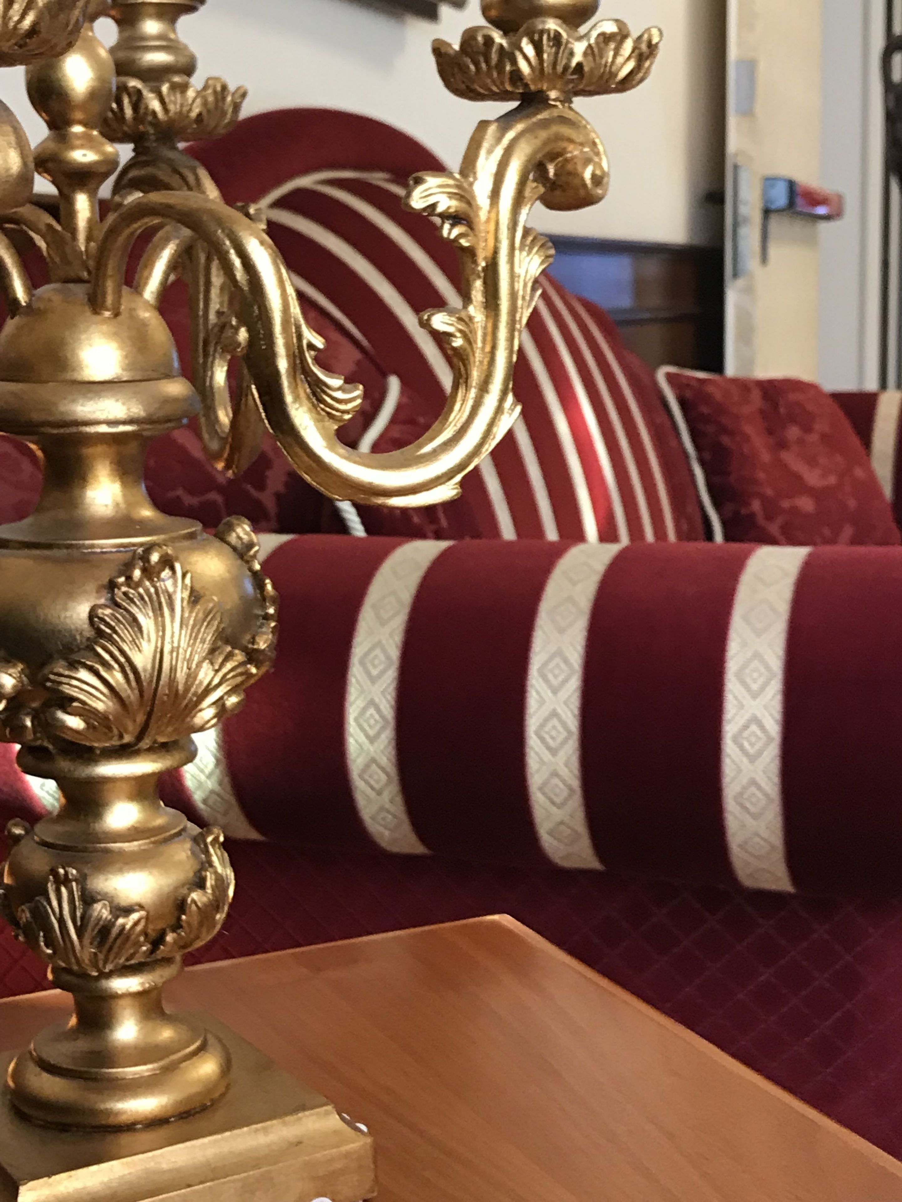 A close-up of a brass decorative item with intricate designs, placed on a wooden surface.