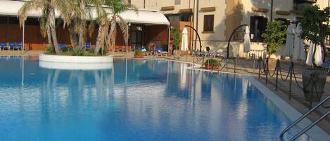 Een seizoensgebonden buitenzwembad en parasols bij het zwembad