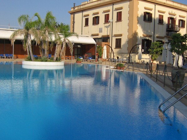 Een seizoensgebonden buitenzwembad en parasols bij het zwembad