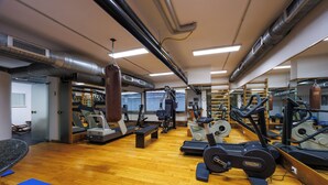 A gym with exercise equipment, wooden flooring, and mirrored walls. - Residence Hotel Torino Uno (Turin)