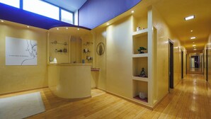 A hotel reception area with a wooden floor, a reception desk, and a wall-mounted artwork. - Residence Hotel Torino Uno (Turin)