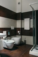 A modern bathroom with a bidet, toilet, and sink.