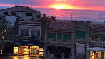 Un atardecer sobre un pueblo costero con edificios y comercios.