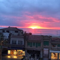 Un atardecer sobre un pueblo costero con edificios y comercios.