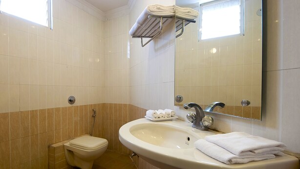 Ein Badezimmer mit Toilette, Waschbecken und Handtuchhalter.