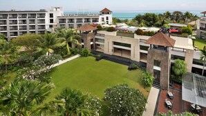 Un hotel con diversi piani, una zona piscina sul tetto e vista sull'oceano.