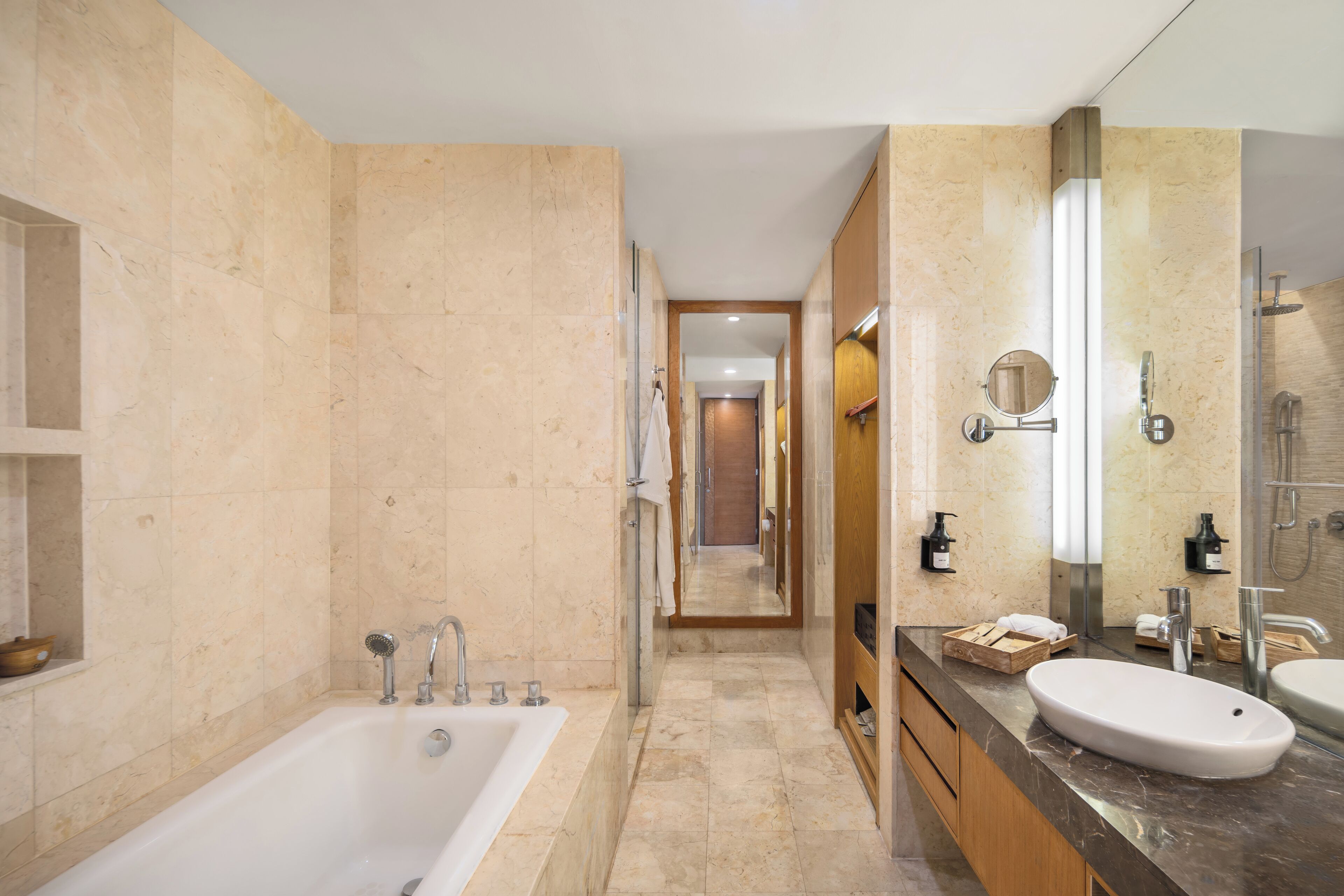 Un baño moderno con una bañera grande, un lavamanos y un espejo.