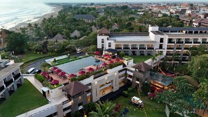 Um resort com piscina, área de refeições ao ar livre e vista para a praia.