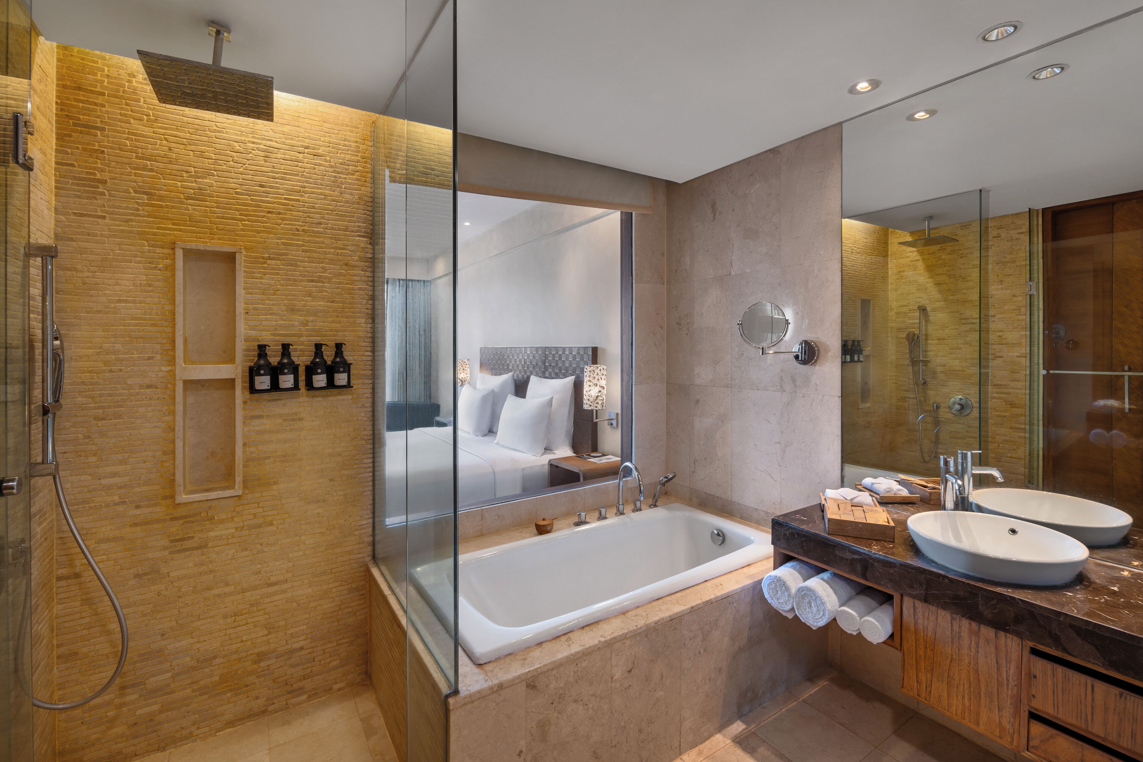 Un baño moderno con ducha envuelta en vidrio, una bañera grande y un tocador doble.