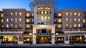 A hotel with a central atrium, multiple balconies, and storefronts on the ground level.