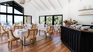 A spacious dining area with high ceilings, large windows, and a central bar area. - Chimes Spa Retreat (Shadforth)