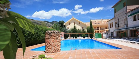 Una piscina al aire libre de temporada, sillones reclinables de piscina