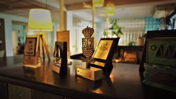 A counter with various awards and plaques, including a crown-shaped award and a plaque with a ship and waves.