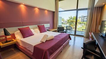 Una habitación de hotel moderna con una cama grande, un escritorio y vistas al exterior.