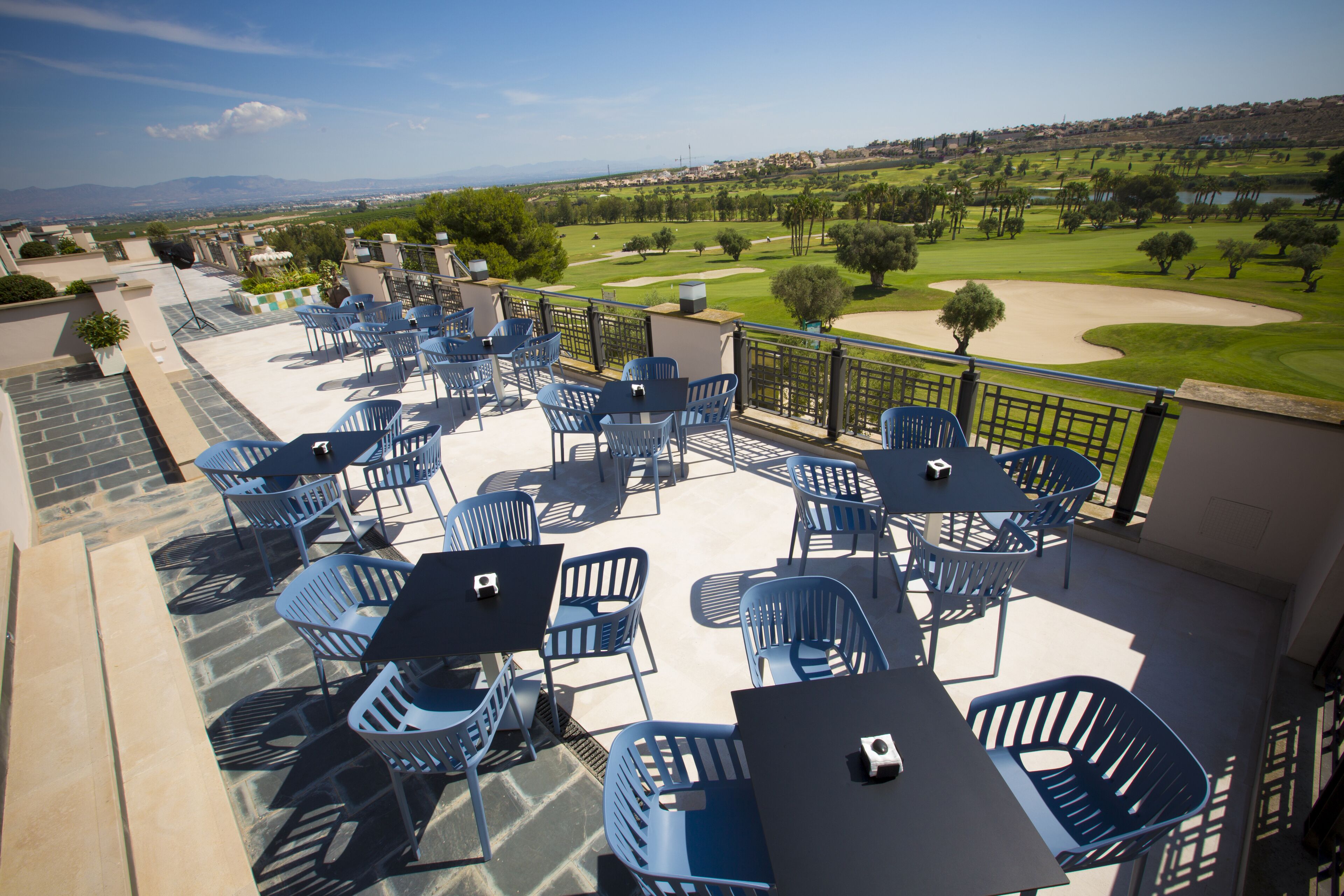 Una terrazza con posti a sedere all'aperto e vista su un campo da golf.