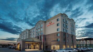 A hotel with a large parking lot and a prominent entrance.