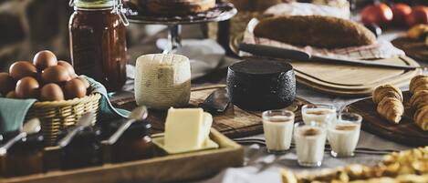 A variety of baked goods, including bread, pastries, and a pie, arranged on a wooden table.