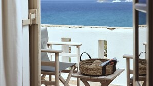 A balcony with a view of the ocean, a wicker basket, and a chair. - Naxos Magic Village Hotel (Naxos)