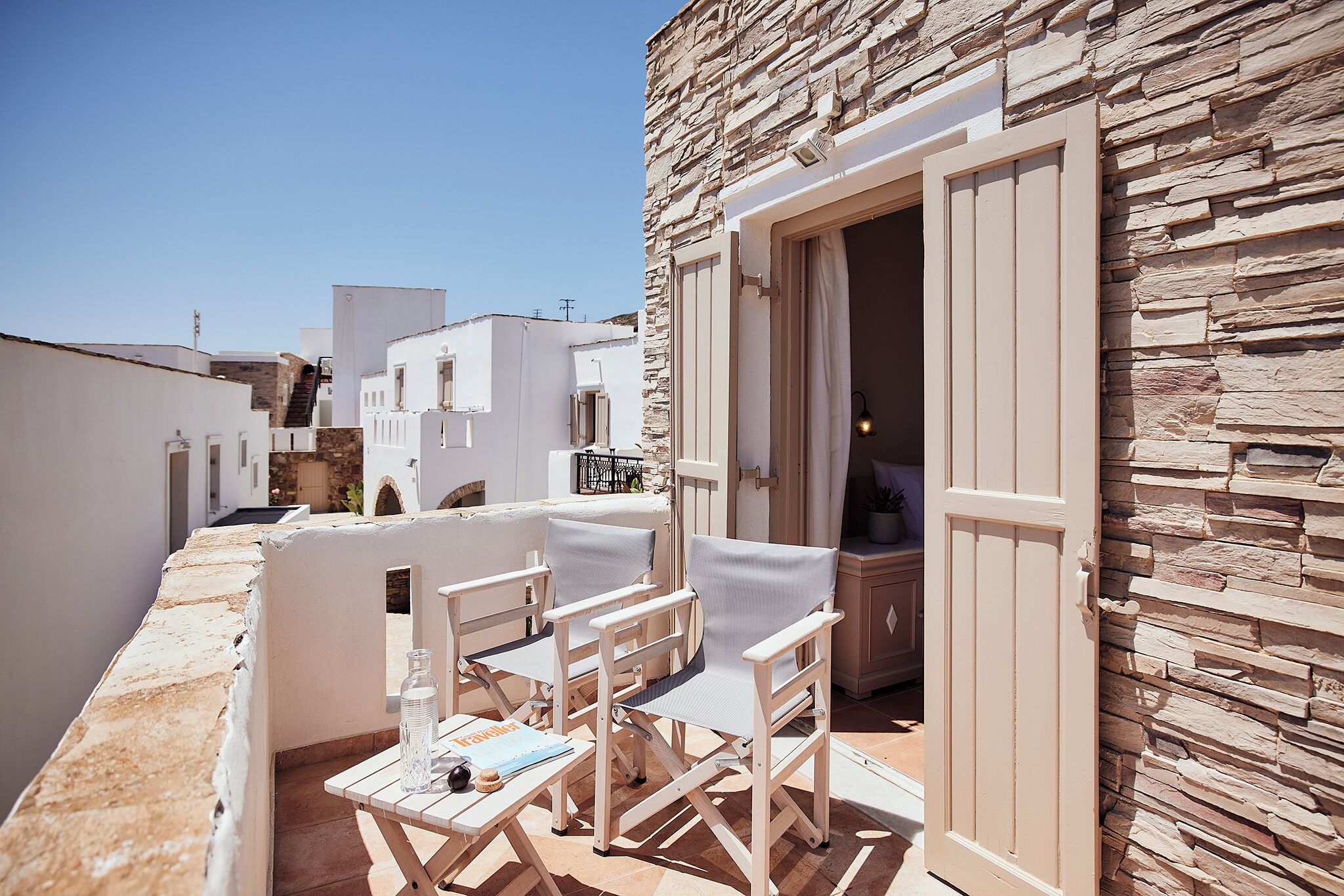 An outdoor seating area with a table, chairs, and a bottle.