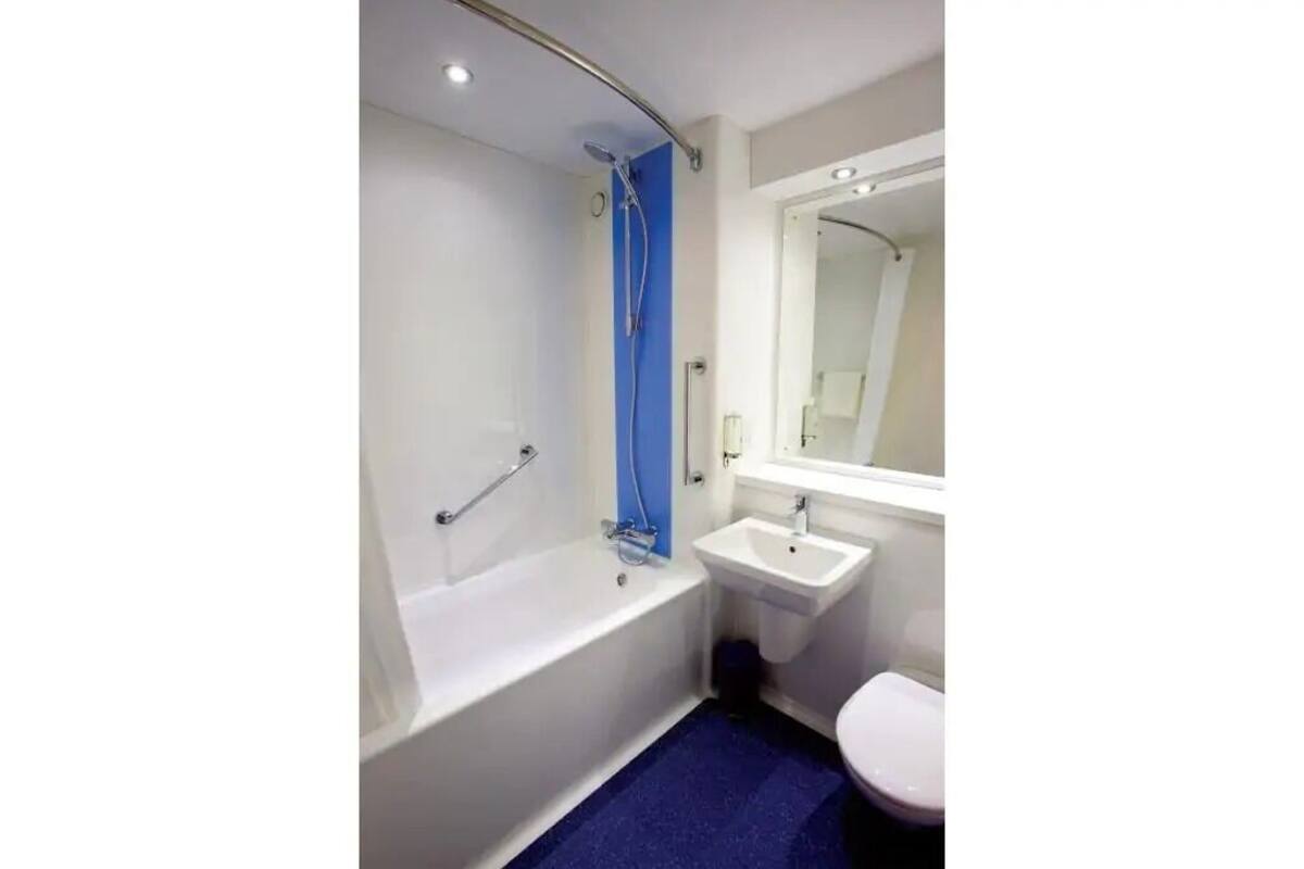 A modern bathroom with a bathtub, a sink, and a toilet.