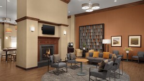 Eine moderne Lobby mit Kamin, Sitzgruppe und Bücherregal.