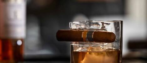 A glass with a cigar and ice cubes.