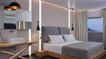 Une chambre d’hôtel moderne, équipée d’un lit, d’une table de chevet et offrant une vue sur la mer.